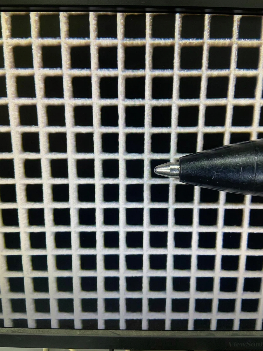 Microscope view of square-hole collimator grid